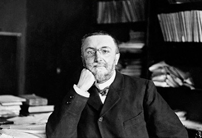 Alfred Binet in office with chin on hand
